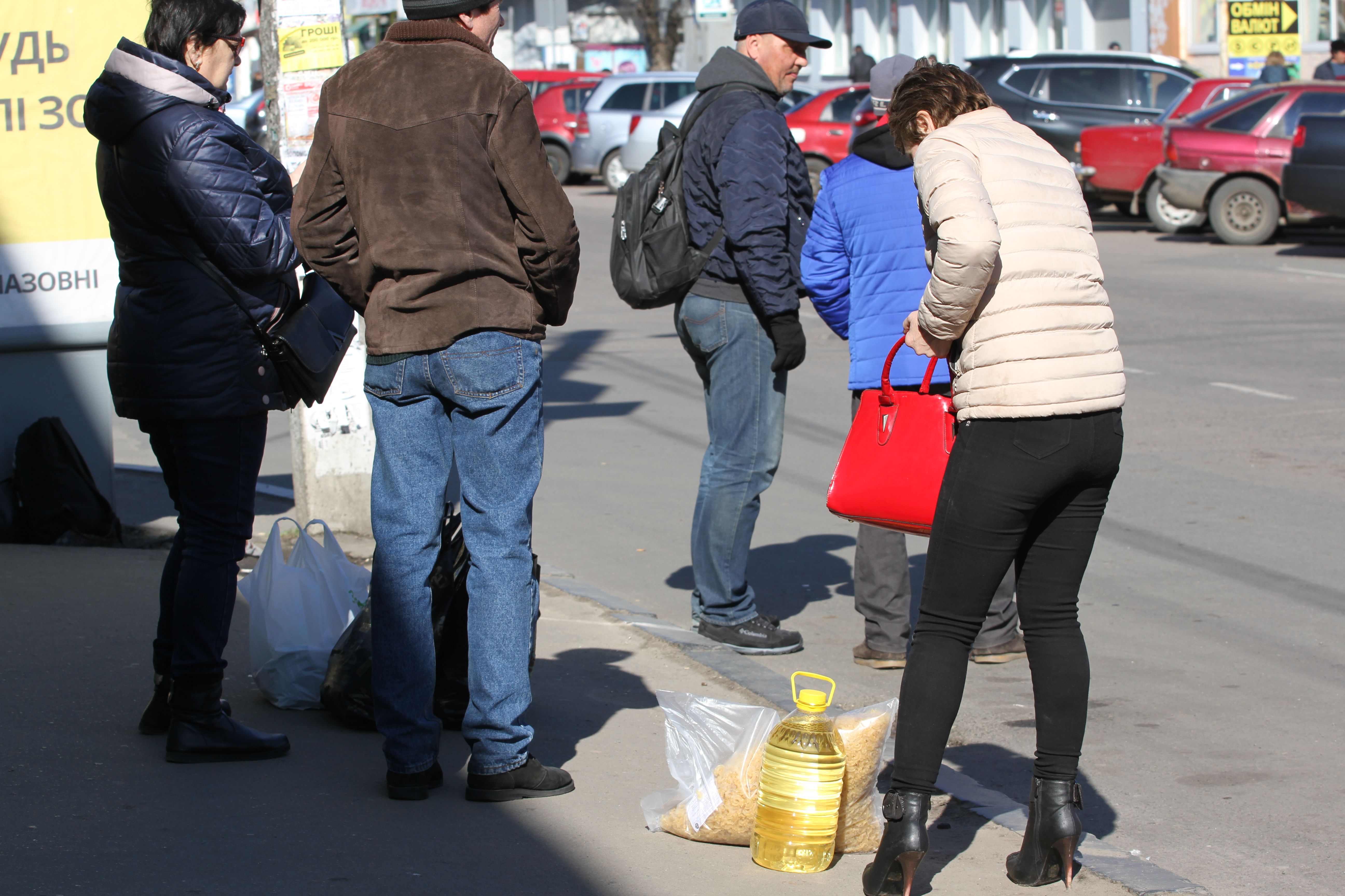 Люди чекають на міські автобуси на зупинці біля центрального продуктового ринку Полтави