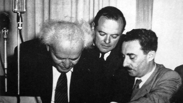 Давид Бен-Гуріон підписує Декларацію незалежності Ізраїлю (крайній справа — Моше Шарет, другий, після Бен-Гуріона, прем'єр-міністр Ізраїлю). Тель-Авів, 14 травня 1948 року
