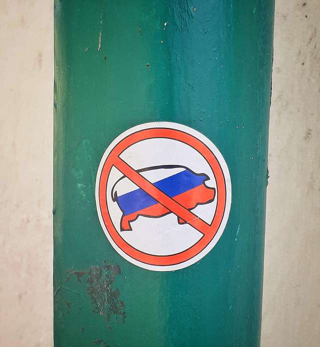 Водостічна труба на великій лаврській стіні, оздоблена патріотичною наліпкою (наші дні)