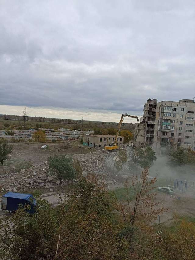 Російські окупанти зносять знищені ними будинки в Маріуполі_1