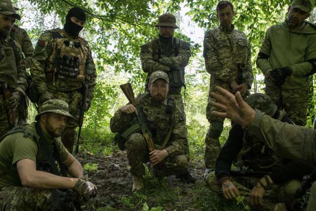 Українські вояки-добровольці слухають інструкції під час тренінгу членів Mozart Group минулого року
