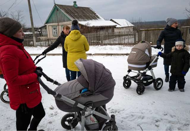 Українські матері та їхні діти чекають на обстеження в Левківці, Україна, від команди, яка надає послуги селянам, які здебільшого не мали доступу до лікарів після початку повномасштабного вторгнення Росії майже рік тому.