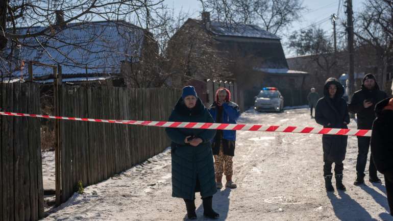 Мешканці чекали за поліцейським оточенням, щоб повернутися до своїх домівок після ракетного обстрілу в передмісті Києва, Україна, у п’ятницю.