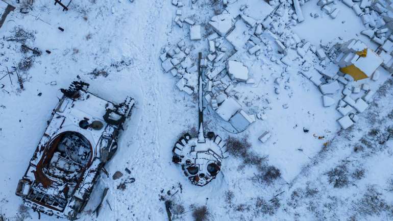Знищений російський танк, засипаний снігом, стоїть у дворі приватного будинку в місті Святогірськ, Україна
