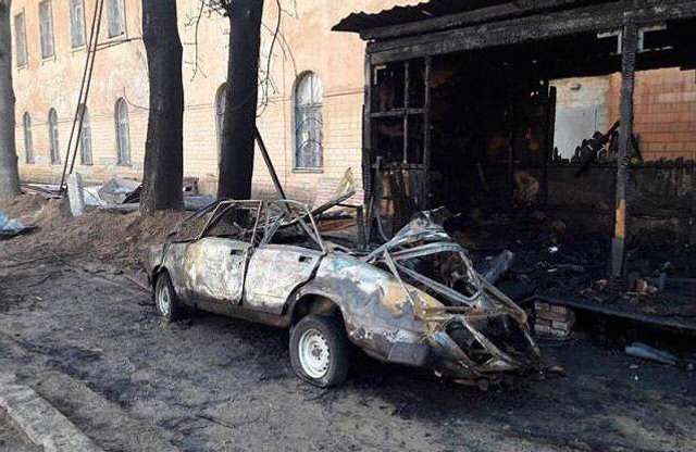 Згорілий автомобіль та будівельний вагончик біля стін Петровського кадетського корпусу
