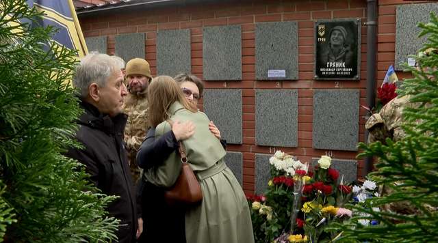 Батьки Олександра Гряника приймають співчуття після поховання урни з прахом сина у колумбарній стіні на Лук'янівському кладовищі у Києві. 28 жовтня 2023 року