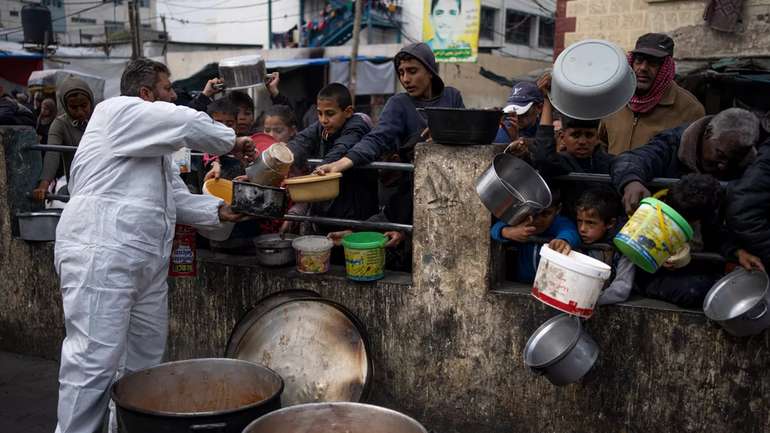 Палестинці вишикуються в чергу по безплатну їжу в Рафаху (сектор Ґаза, 23.II.2024)