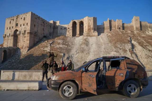 Сирійські повстанці на тлі цитаделі Алеппо