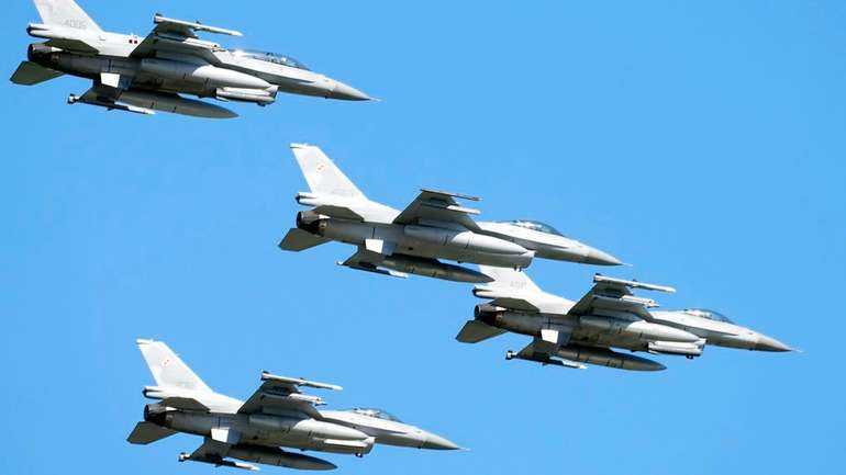 Винищувачі F-16 американського виробництва пролітають у небі над столицею Польщі, беручи участь у масштабному військовому параді на честь Дня польської армії